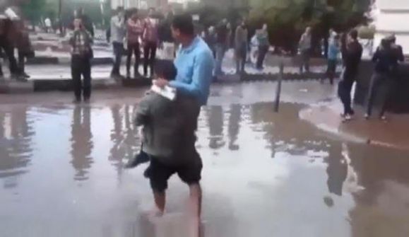  فيديو.. وسط الأمطار مصري يحمل الناس من رصيف لآخر مقابل 'جنيه للفرد'