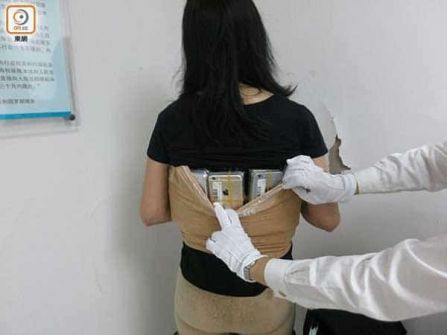 بالصور: بهذه الطريقة حاولت سيدة صينية تهريب 102 آيفون!